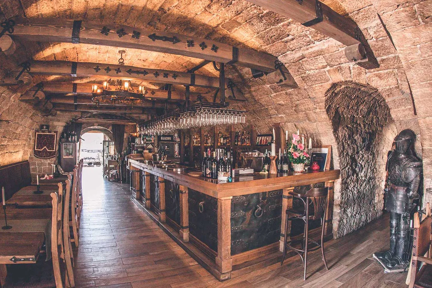 Stvarna fotografija kamenih svodova i drvenog bara restorana Kazamat