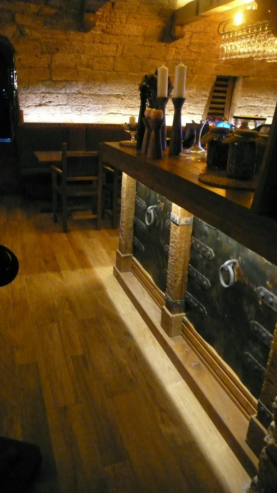 Svijeće, čaše i drveni bar u Kazamatu